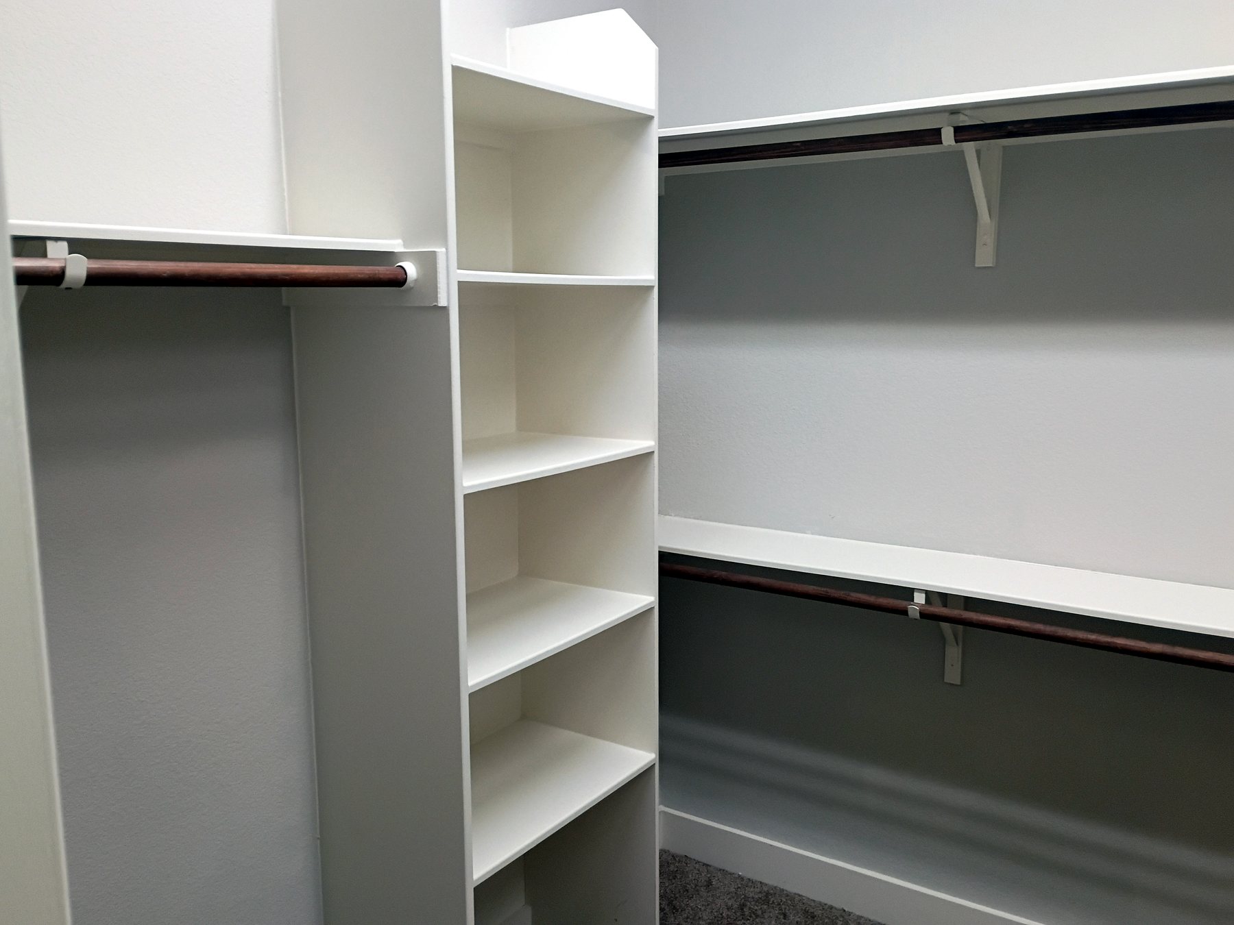 Existing walk-in closet shelving repainted and refreshed as part of an Austin residential make-ready.