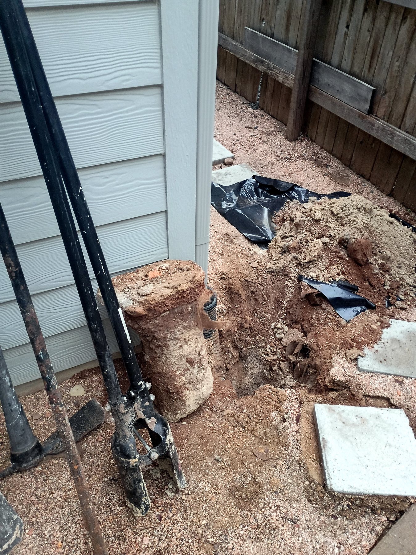 Excavation for replacement of a failed wood-fence post at an Austin-area property.