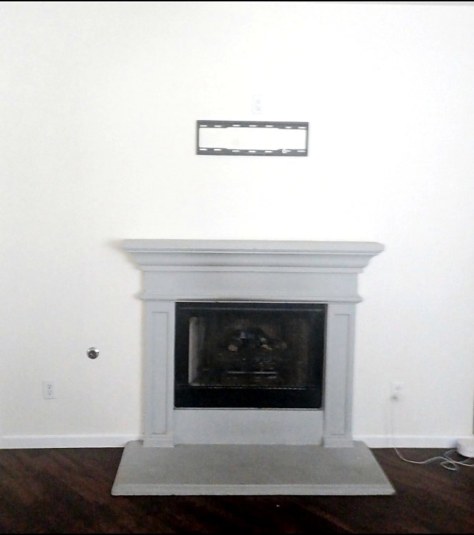 Fireplace area before a complete mantel, hearth, surround, and finish-work rebuild.