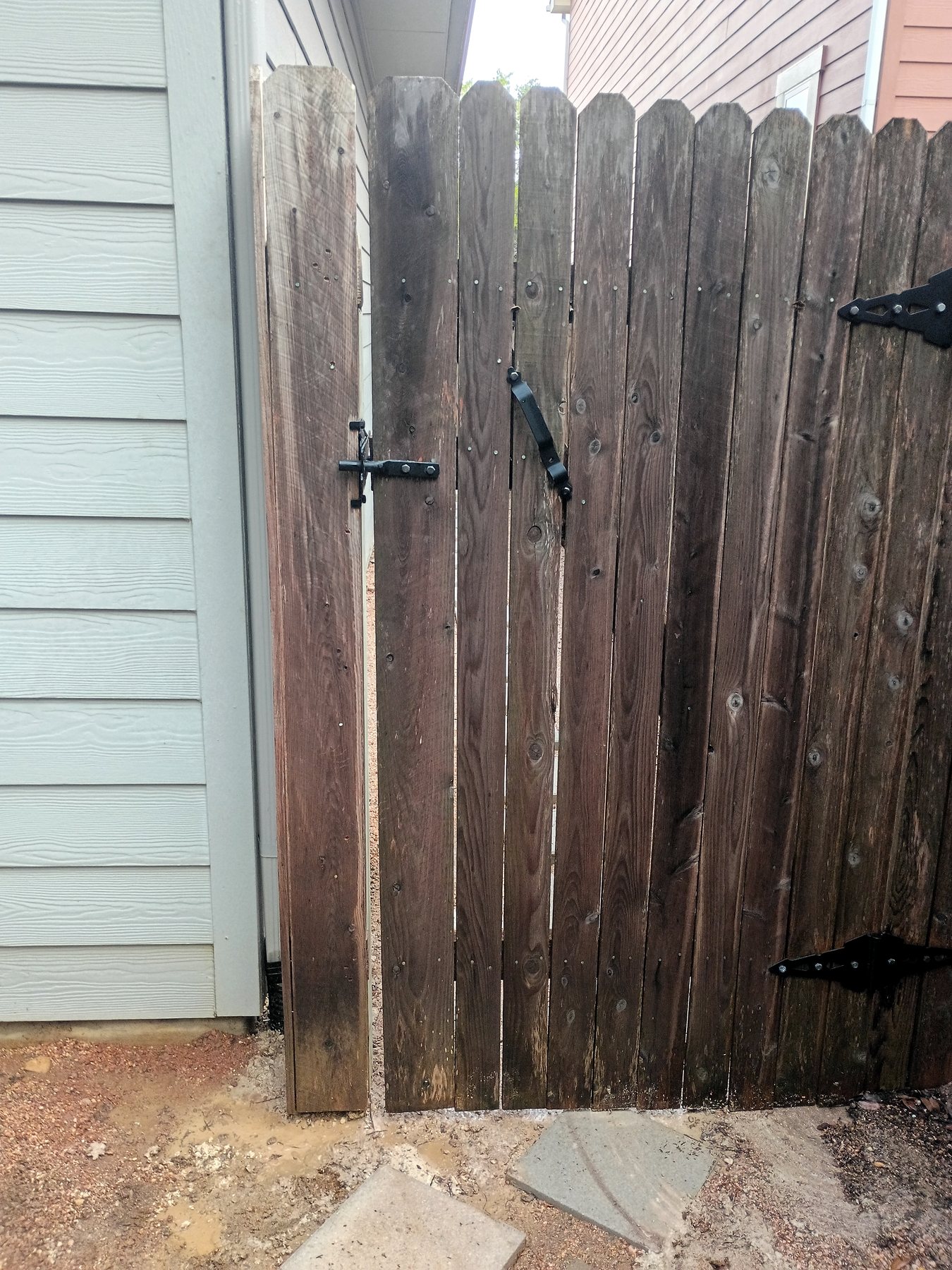 Wood privacy-fence gate realigned after fence-post replacement in Austin.