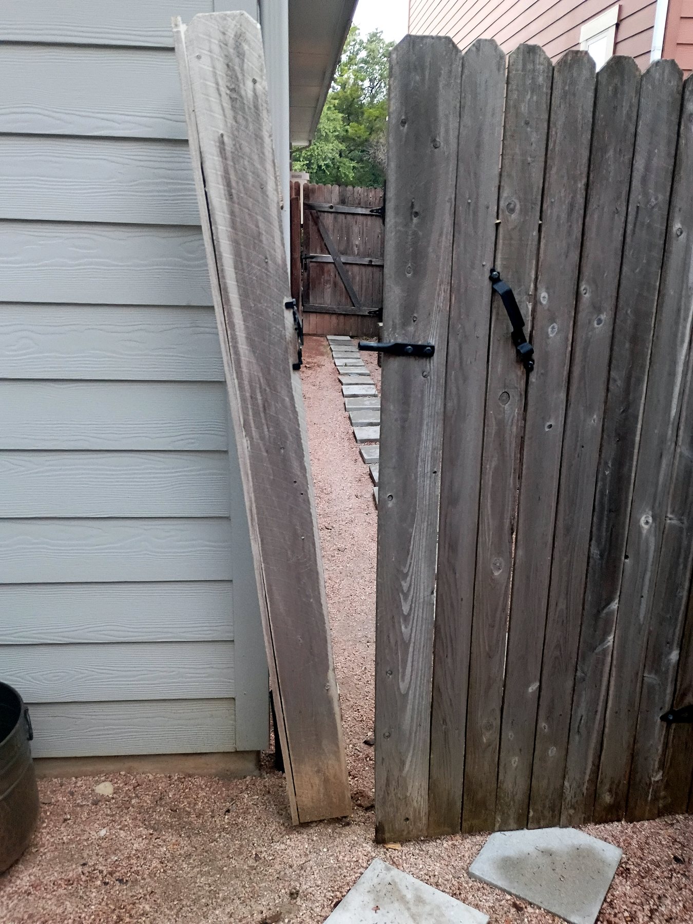 Wood privacy-fence gate before post replacement and realignment by Affordable Handyman Services in Austin.